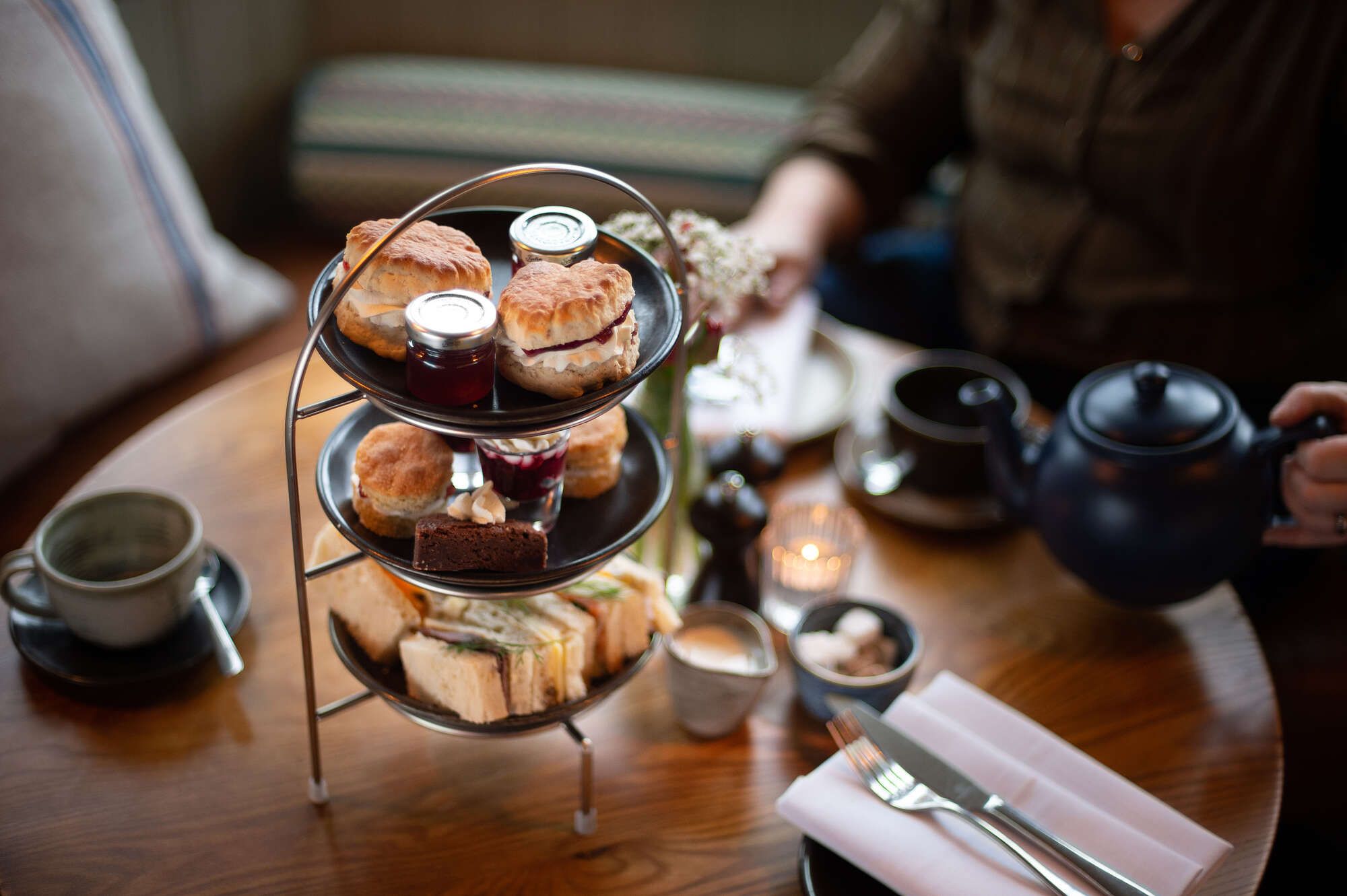 Afternoon tea with Jam scones, cream cups of tea and finger sandwiches