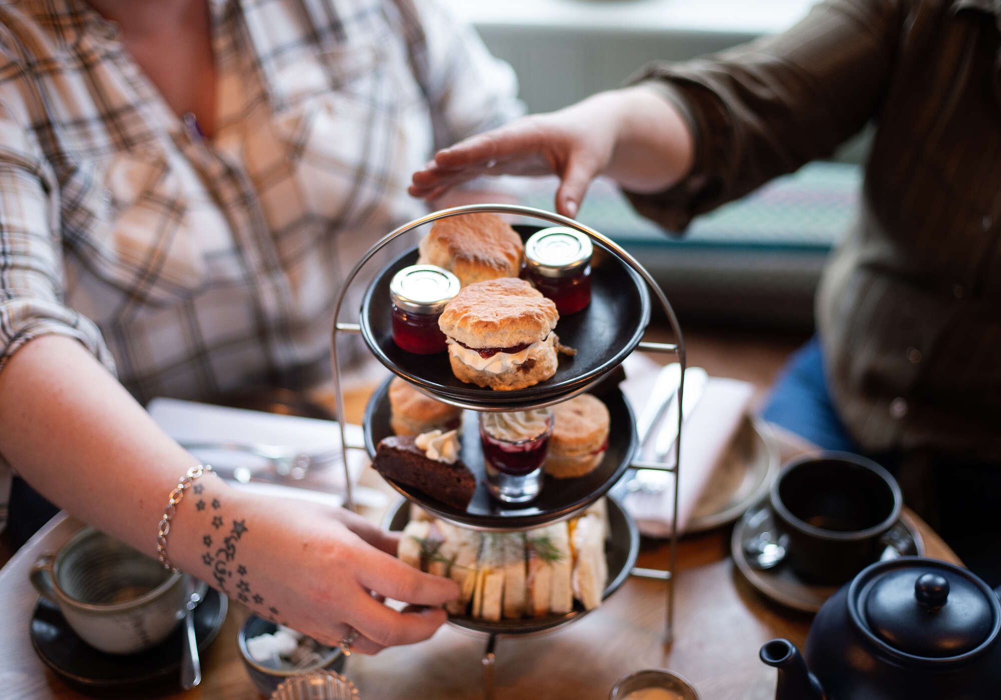 People enjoying the Afternoon tea with scones, jam, sandwiches