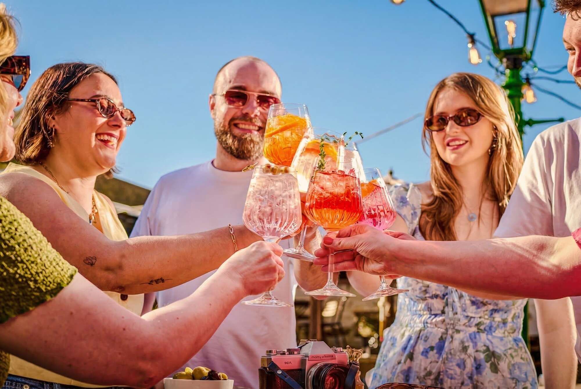 Group of people drinking Spritz in the Sunshine - Aperol & Hugo Spritz