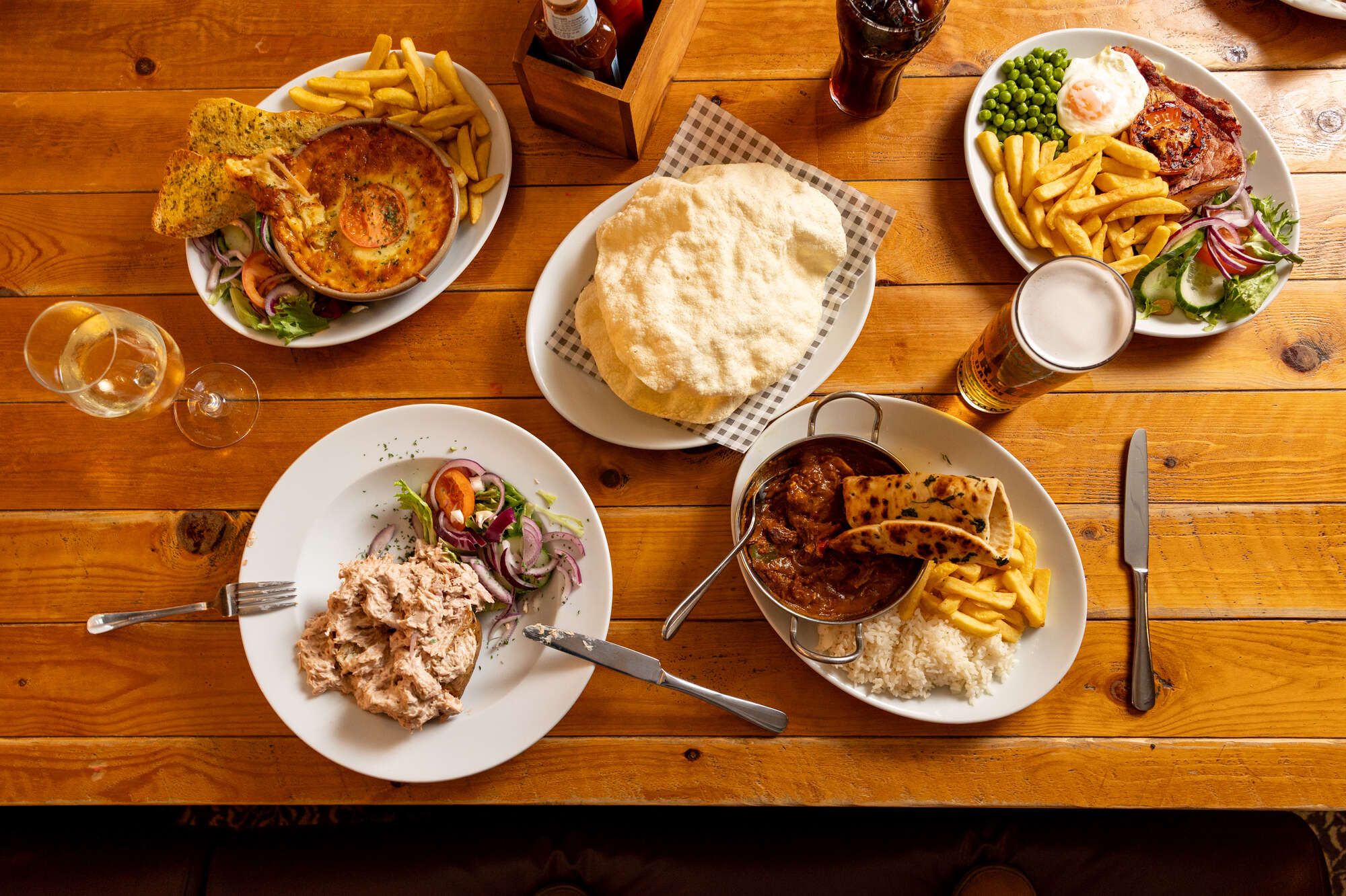 Food on the table, Tuna salad, Curry with chips, poppadom, Pie and chips and pint of beer