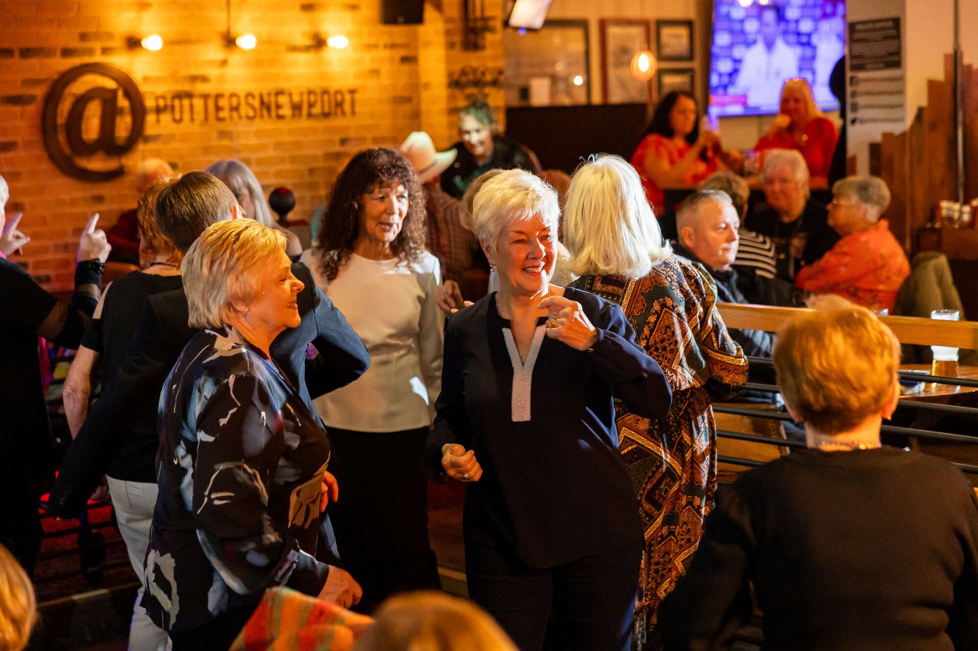Lady dancing with ;ots of others on the dance floor