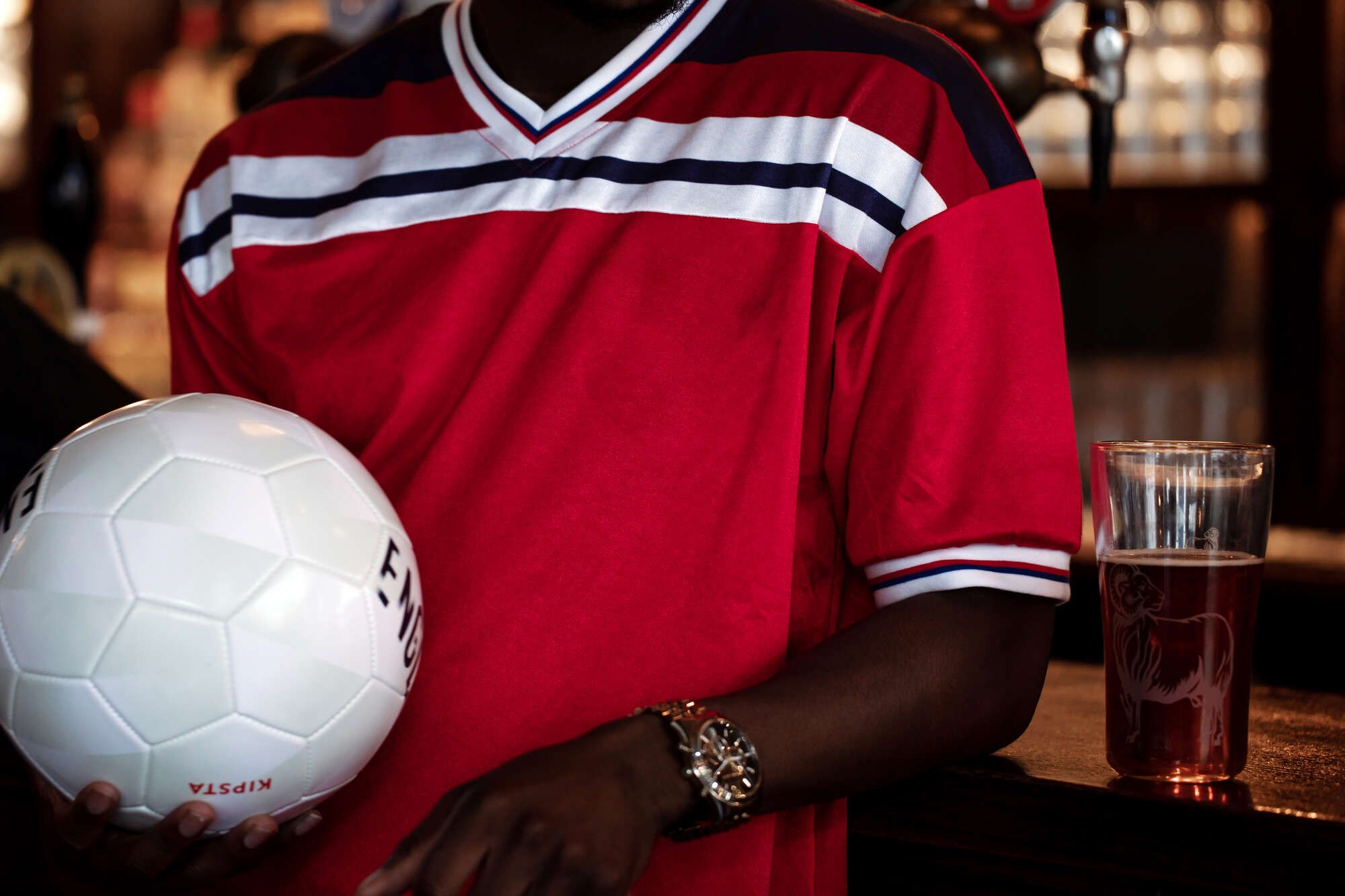 Man holding a football at the bar